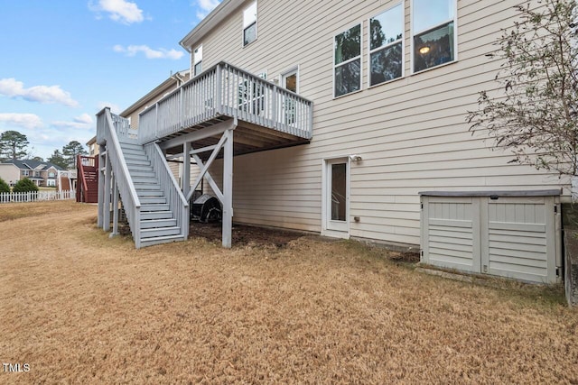 back of property with a deck and a lawn