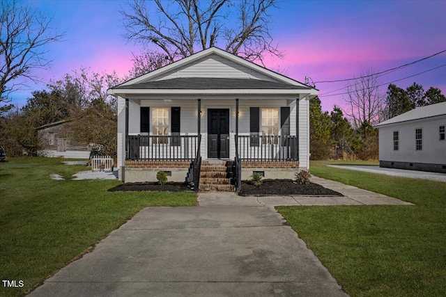 bungalow-style house with a yard and covered porch