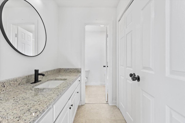 bathroom featuring vanity, tile patterned floors, and toilet