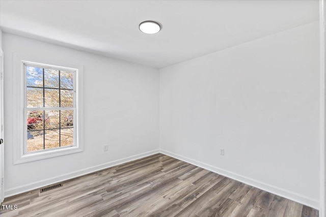 spare room featuring a healthy amount of sunlight and light hardwood / wood-style flooring