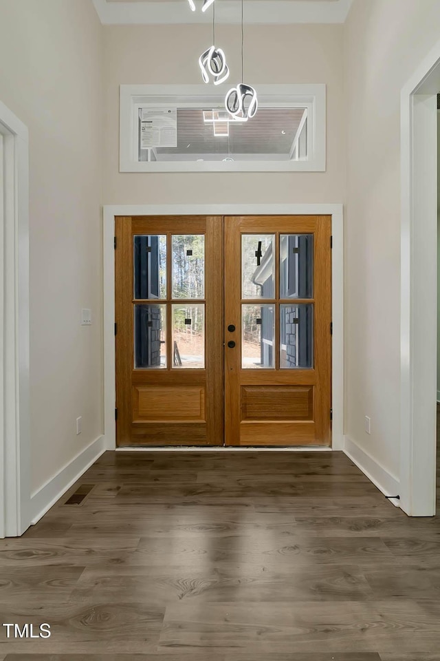 doorway to outside with dark wood-type flooring, french doors, and a high ceiling