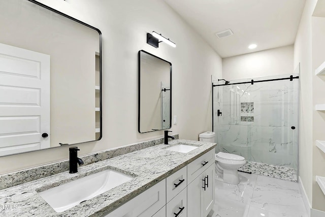 bathroom with vanity, a shower with door, and toilet