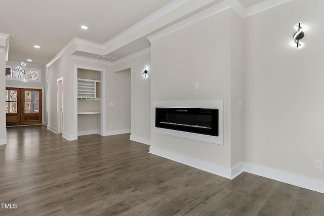 unfurnished living room with ornamental molding, dark hardwood / wood-style floors, built in features, and french doors