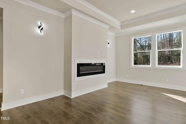 unfurnished living room featuring crown molding, dark hardwood / wood-style floors, and a tray ceiling