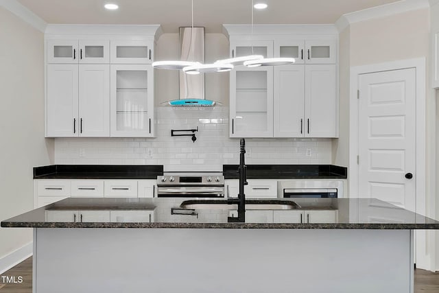 kitchen featuring white cabinetry, tasteful backsplash, a center island with sink, dark hardwood / wood-style flooring, and stainless steel range with electric cooktop