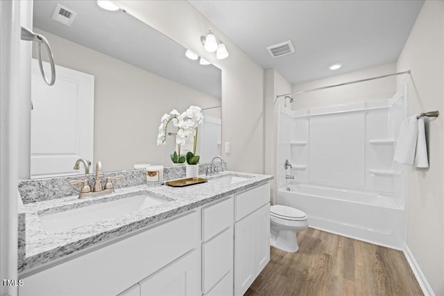 full bathroom with wood-type flooring, shower / washtub combination, vanity, and toilet