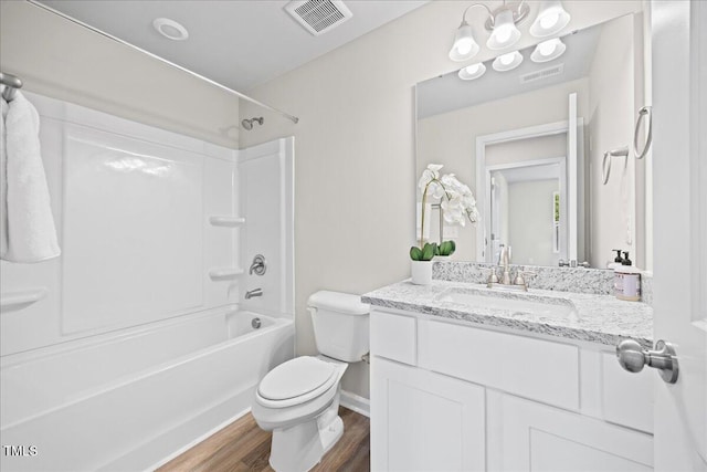 full bathroom with wood-type flooring, toilet,  shower combination, and vanity