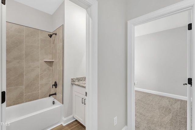 bathroom featuring tiled shower / bath combo and vanity