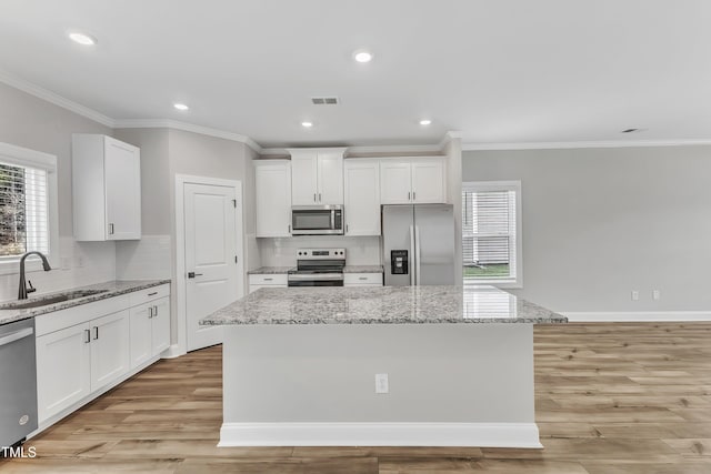 kitchen with sink, white cabinetry, a center island, and stainless steel appliances