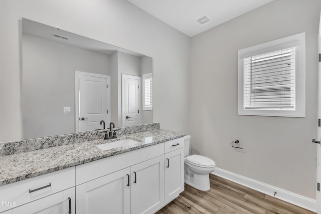 bathroom with hardwood / wood-style floors, toilet, and vanity