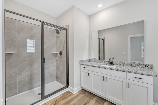 bathroom with hardwood / wood-style flooring, an enclosed shower, and vanity