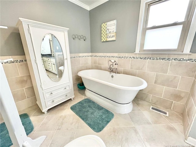 bathroom featuring tile walls, tile patterned flooring, vanity, a washtub, and crown molding