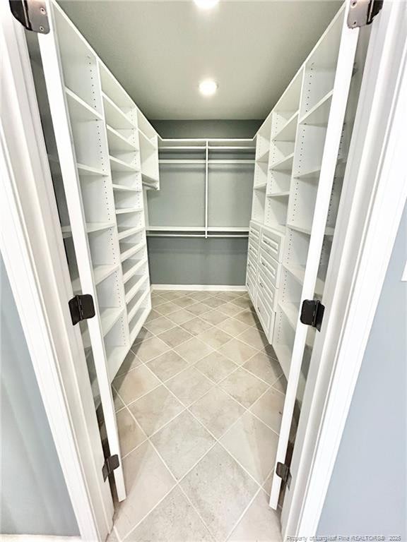 spacious closet with light tile patterned floors