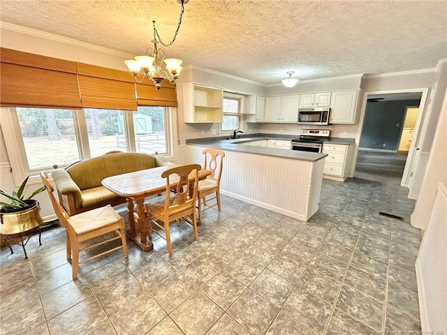 kitchen featuring sink, decorative light fixtures, appliances with stainless steel finishes, kitchen peninsula, and white cabinets