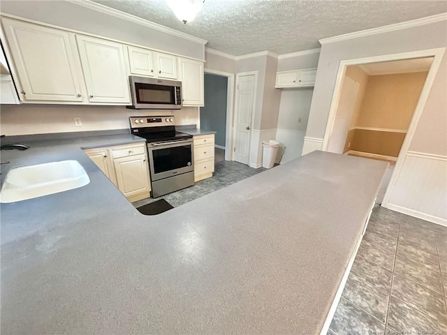 kitchen featuring sink, crown molding, white cabinetry, a textured ceiling, and appliances with stainless steel finishes