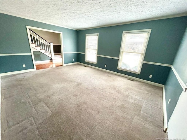 spare room with a textured ceiling and carpet flooring