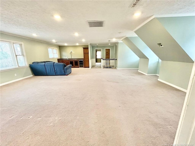 interior space featuring ornamental molding, carpet floors, and a textured ceiling