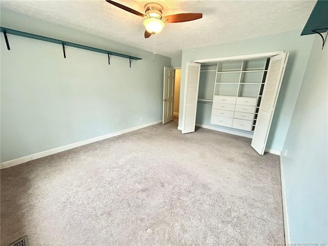 unfurnished bedroom featuring light carpet, ceiling fan, a closet, and a textured ceiling