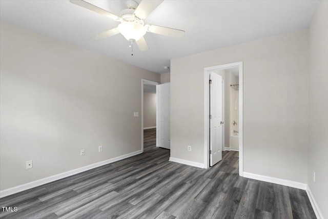 unfurnished bedroom with ensuite bath, dark wood-type flooring, and ceiling fan