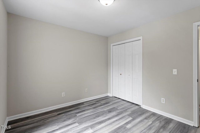 unfurnished bedroom with hardwood / wood-style floors and a closet