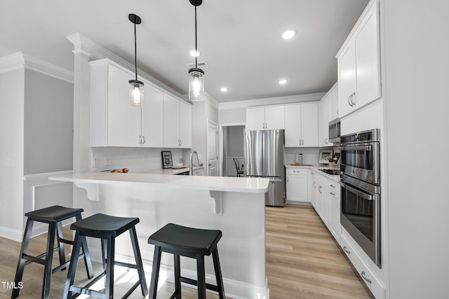 kitchen featuring white cabinetry, stainless steel appliances, decorative light fixtures, and decorative backsplash