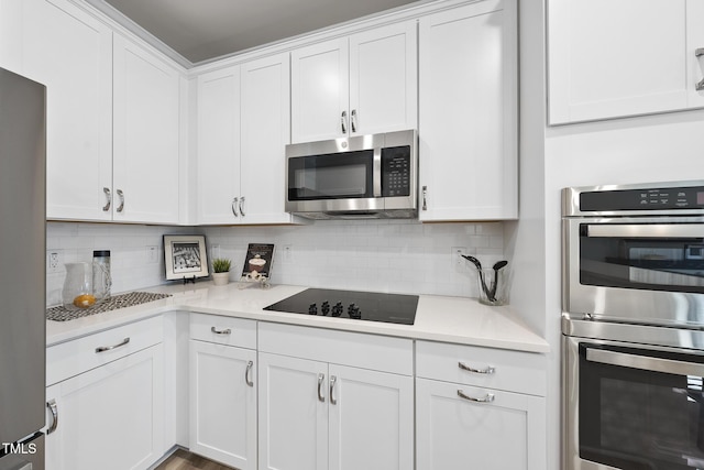 kitchen with white cabinetry, stainless steel appliances, and decorative backsplash