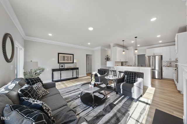 living room with ornamental molding and light hardwood / wood-style flooring