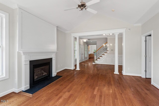 unfurnished living room with ceiling fan, a glass covered fireplace, wood finished floors, lofted ceiling, and stairway