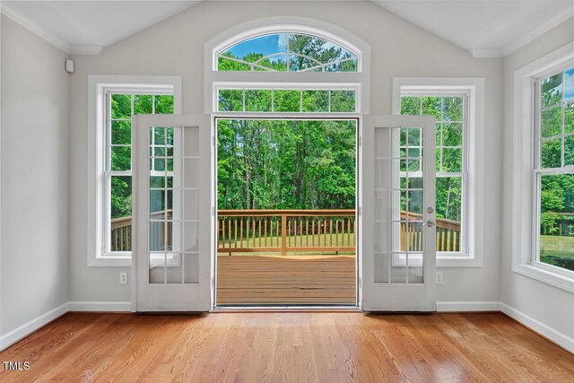 entryway with baseboards, light wood-style flooring, and vaulted ceiling
