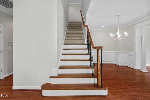 staircase with visible vents, wood finished floors, a chandelier, ornamental molding, and recessed lighting