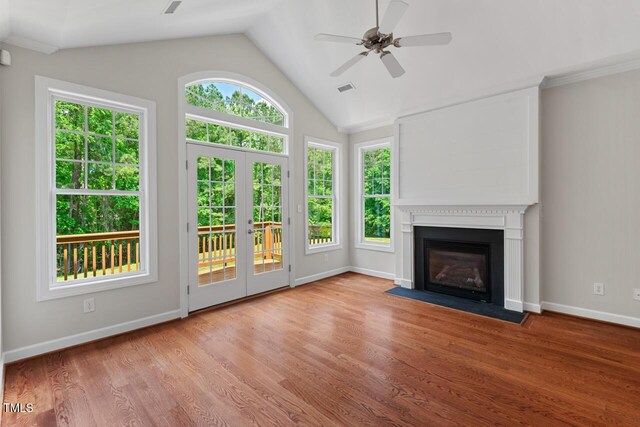 unfurnished living room with a healthy amount of sunlight, ceiling fan, a fireplace with flush hearth, and visible vents