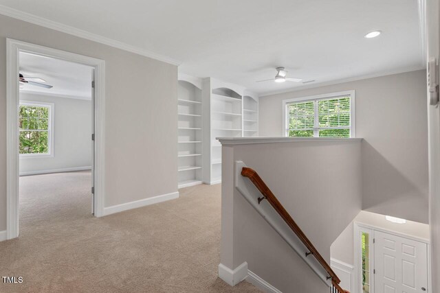 hall featuring baseboards, plenty of natural light, light colored carpet, and an upstairs landing