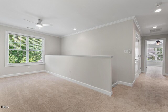 spare room with crown molding, carpet floors, a ceiling fan, and visible vents