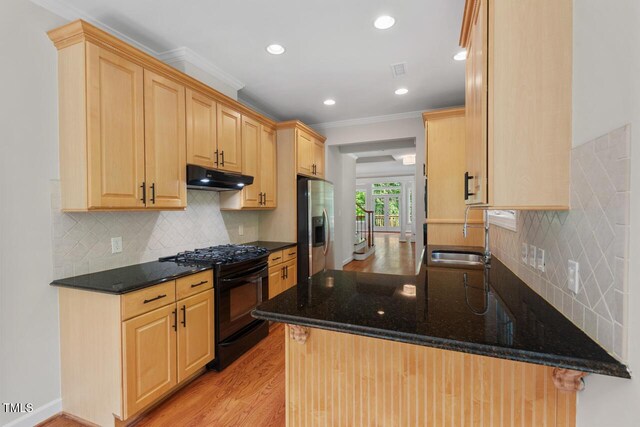 kitchen with a sink, stainless steel fridge with ice dispenser, light wood-style flooring, under cabinet range hood, and black gas range