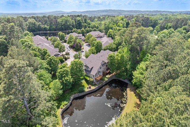 drone / aerial view with a residential view, a water view, and a wooded view