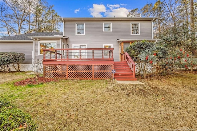 back of property with a deck and a lawn