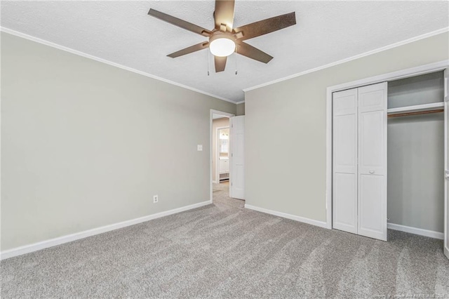 unfurnished bedroom featuring crown molding, carpet flooring, a closet, and ceiling fan