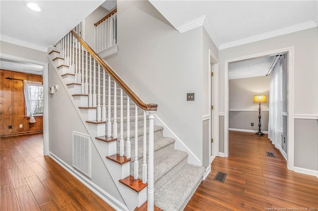 stairway featuring hardwood / wood-style floors and crown molding