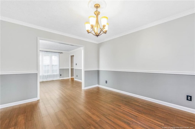 unfurnished room featuring hardwood / wood-style flooring, a chandelier, and ornamental molding