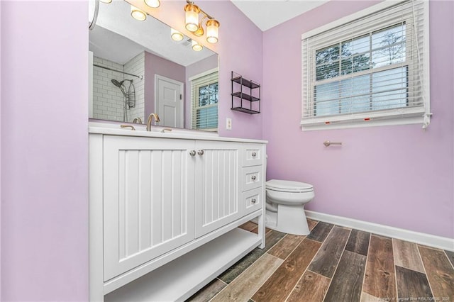 bathroom with toilet, vanity, and walk in shower