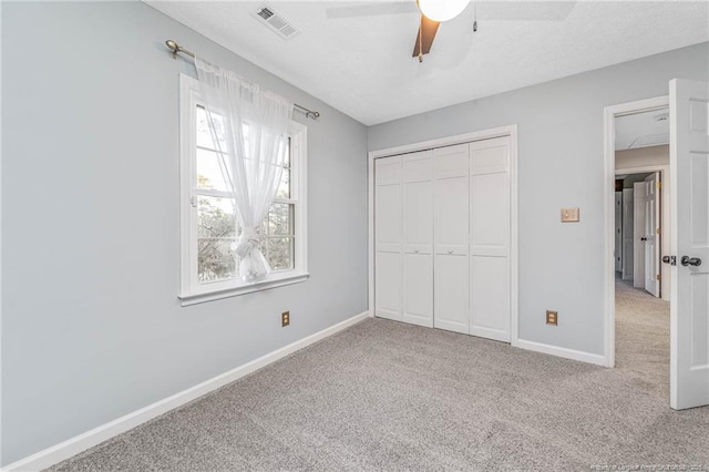 unfurnished bedroom with a closet, ceiling fan, and carpet flooring