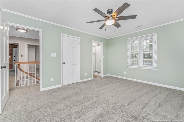 unfurnished bedroom featuring ceiling fan, crown molding, light carpet, and a textured ceiling