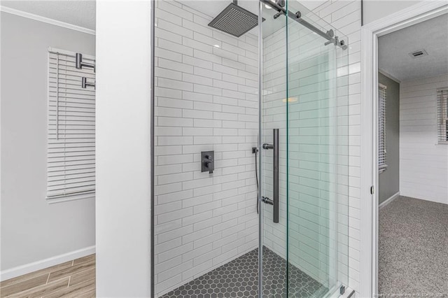 bathroom featuring crown molding and a shower with shower door