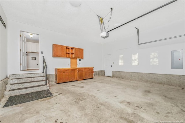 garage with a garage door opener and electric panel