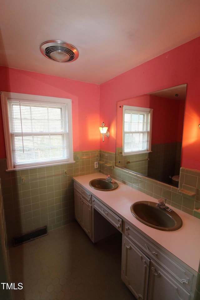 bathroom featuring tile walls, tile patterned floors, and vanity