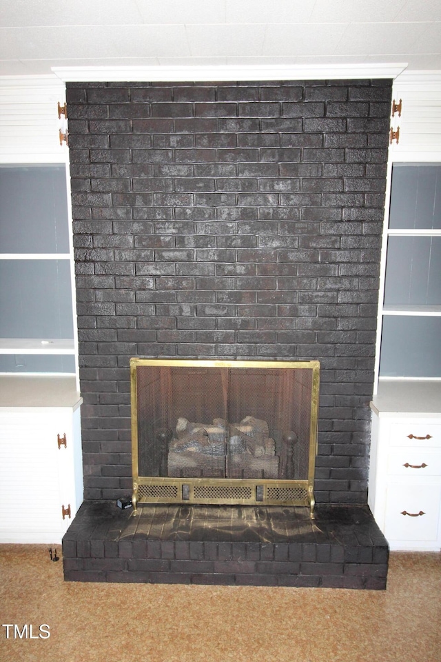 interior details with carpet floors, crown molding, and a fireplace