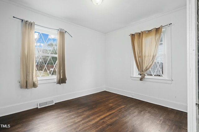 empty room featuring dark hardwood / wood-style floors and ornamental molding