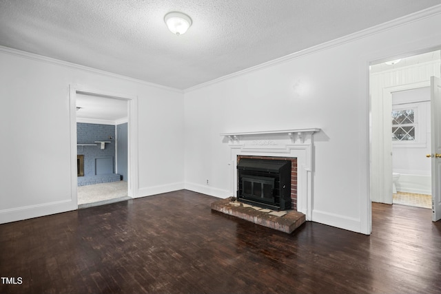 unfurnished living room with dark wood-type flooring, a textured ceiling, ornamental molding, and a fireplace