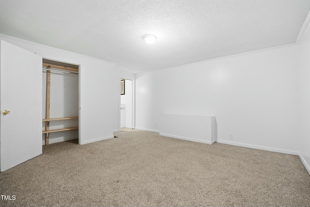 unfurnished bedroom featuring crown molding, a textured ceiling, carpet floors, and a closet