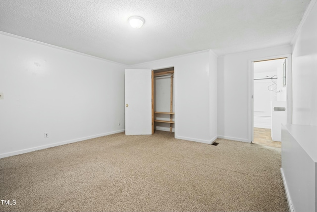 unfurnished bedroom with a closet, carpet flooring, crown molding, and a textured ceiling